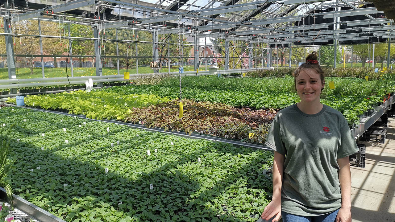 Brianna Garrett standing in a greenhouse.