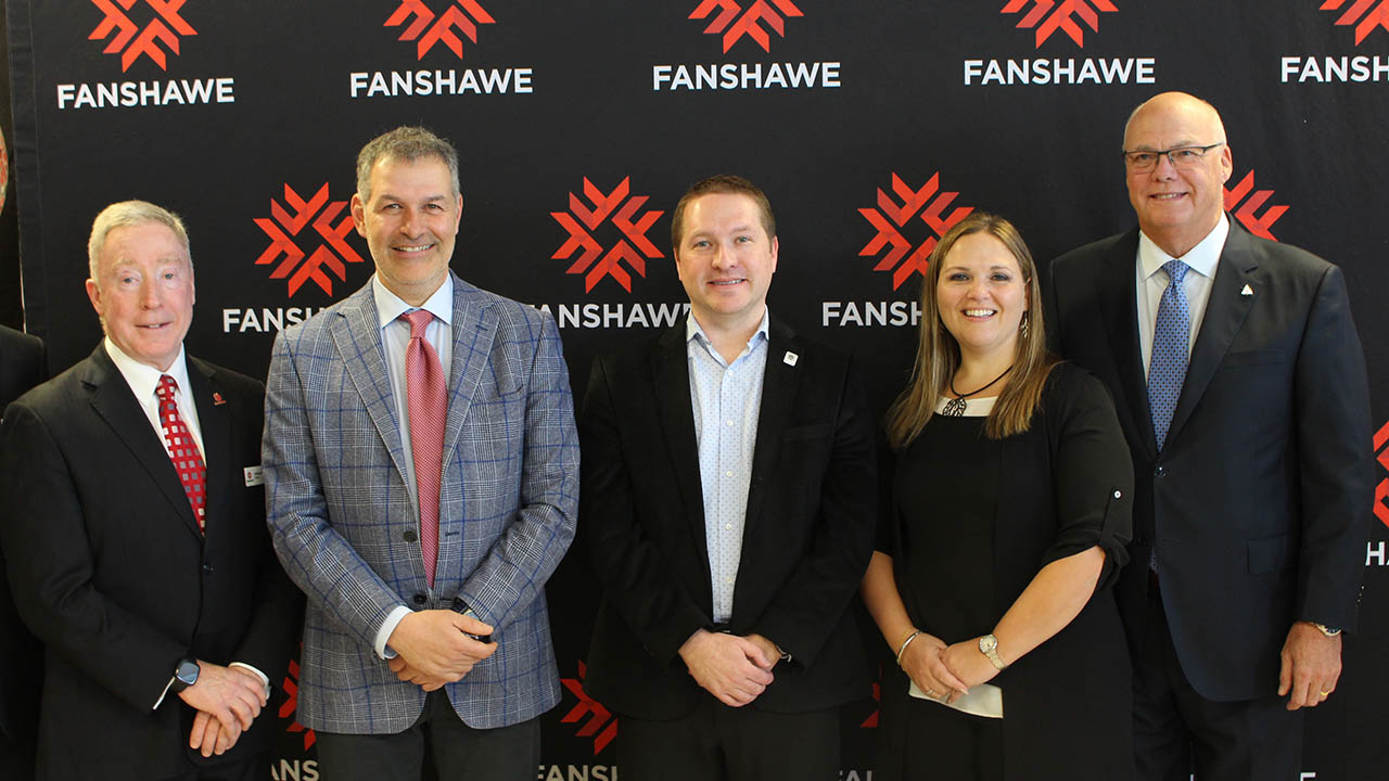 Peter Devlin and members of the Crich family in front of a Fanshawe College backdrop.