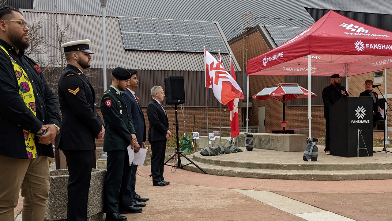 Representatives from Fanshawe College and the military standing at an outdoor Remembrance Day ceremony.
