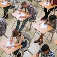 Students sitting at desks, writing on papers.