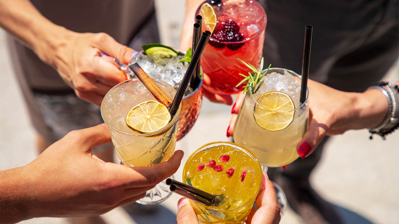Stock image of people clinking glasses with various mocktails