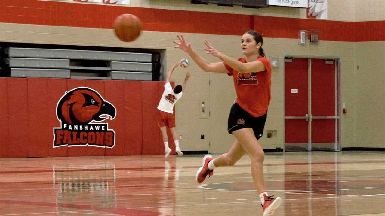 Sydney Kendellen playing basketball on the Fanshawe court with her teammates.