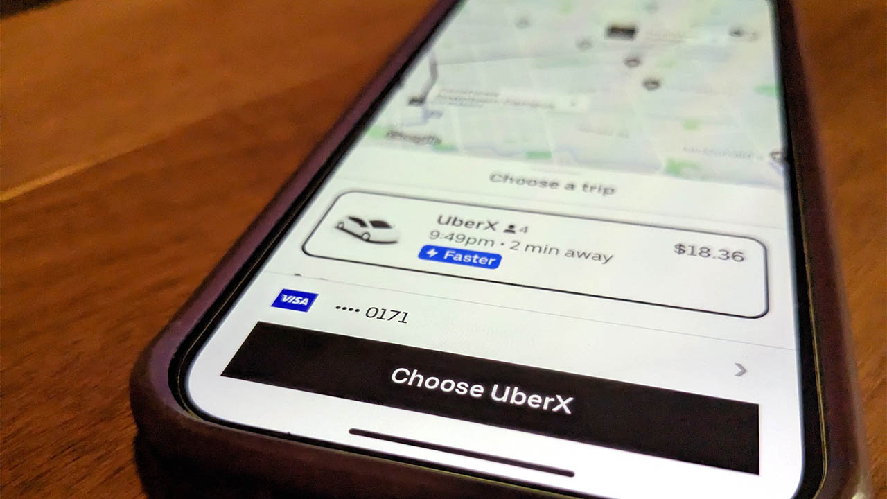 A phone screen displays the Uber app.