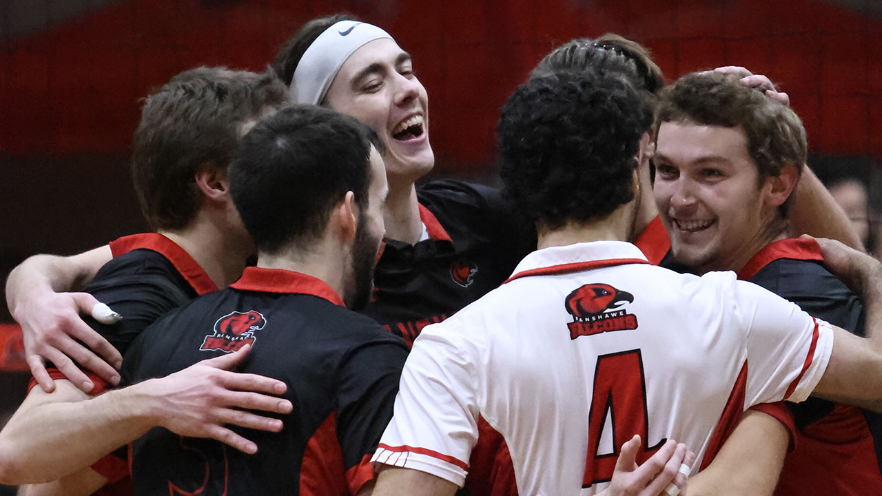 A photo of the Fanshawe men’s volleyball team huddling after their win.