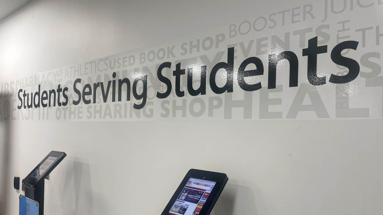 An image of the Fanshawe Student Union office. The message on the wall states: Students Serving Students