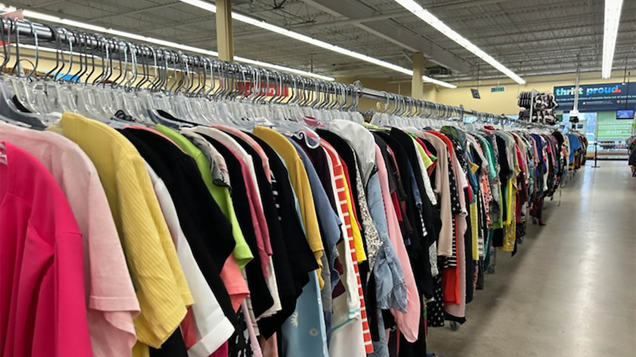 Photo of clothes on a rack at a thrift store.