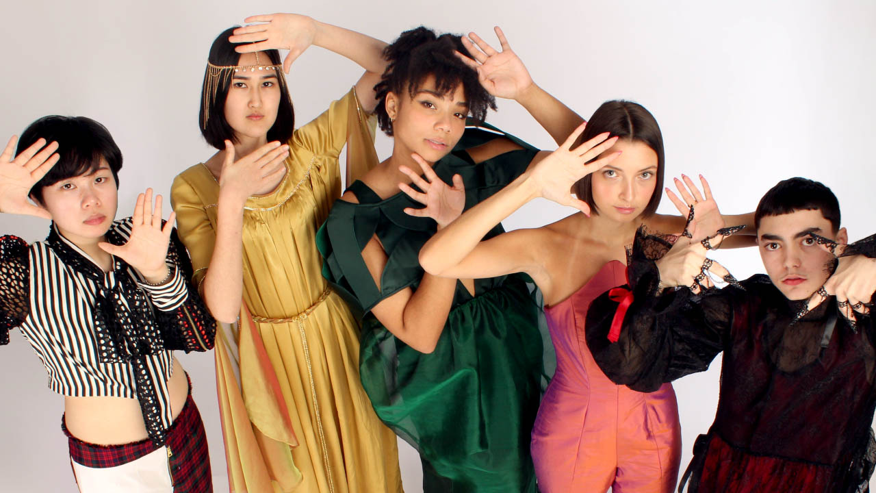 Models pose for photoshoot, displaying student-designed garments.