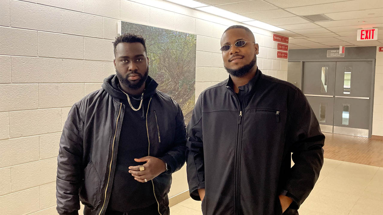 A photo of Lexian Brown (left) and Solomon Ehiemua (right) posing in the halls of Fanshawe College.