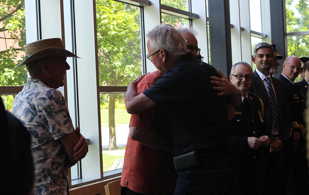 Survivor, Jarmo Stromberg (black shirt) embraces one of his friends who saved him